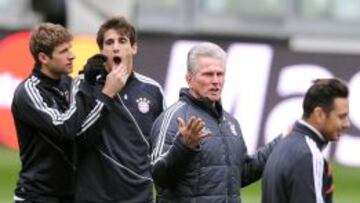 El entrenador del Bayern Múnich, Jupp Heynckes (2d), gesticula delante de los jugadores Thomas Müller (i) y Javi Martínez (2i) durante el entrenamiento de su equipo en Turín, Italia.