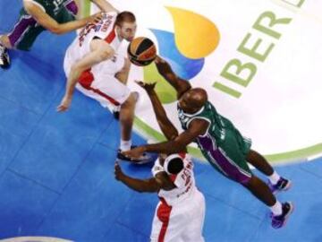 Caleb Green (Unicaja) entra a canasta en el partido contra el Olympiacos, entre Lojeski y Petway.