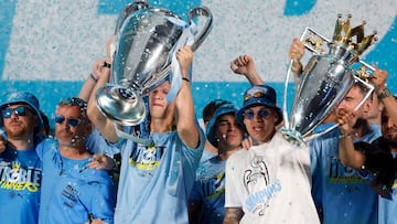 Soccer Football - Manchester City Victory Parade - Manchester, Britain - June 12, 2023 Manchester City's Erling Braut Haaland celebrates on stage with the Champions League trophy as Ederson and Riyad Mahrez celebrate with the Premier League trophy Action Images via Reuters/Jason Cairnduff