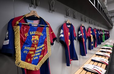 Vista general del banderín del partido, exhibido junto a una camiseta en el vestuario del FC Barcelona antes del partido de vuelta de cuartos de final de la UEFA Champions League 2024/25.