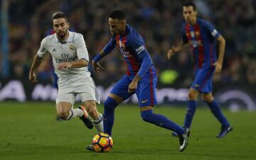 Barcelona's Neymar runs with the ball past Real Madrid's Daniel Carvajal