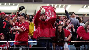 San Francisco 49ers fans hold up signs during Super Bowl LVIII Opening Night at Allegiant Stadium.