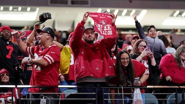 San Francisco 49ers fans hold up signs during Super Bowl LVIII Opening Night at Allegiant Stadium.