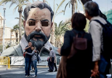 Unos turistas se hacen una foto frente a una falla con el rostro de Sorolla diseñada y pintada por el artista Escif en la plaza de la Reina. 