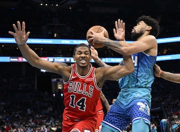 Nick Richards #14 of the Charlotte Hornets battles Malcolm Hill #14 of the Chicago Bulls for a rebound during the first half of their game at Spectrum Center on February 09, 2022 in Charlotte, North Carolina. 