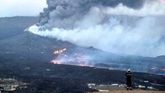 In this handout photograph taken on November 17, 2021 and released by the Spanish Military Emergency Unit (UME) on November 18, 2021, an UME member monitors the lava flows from La Laguna, following the eruption of the Cumbre Vieja volcano on the Canary is