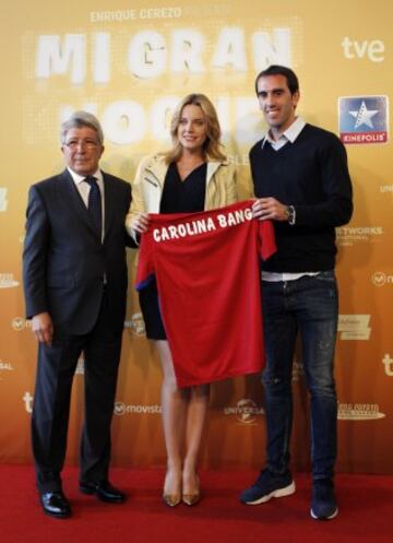Carolina Bang recibe la camiseta del Atlético de Madrid de manos de Cerezo y Godín.