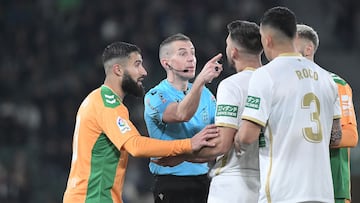 Players argue with Spanish referee Javier Iglesias Villanueva (C)during the Spanish League football match between Elche CF and Real Betis at the Martinez Valero stadium in Elche, on February 24, 2023. (Photo by Jose Jordan / AFP)