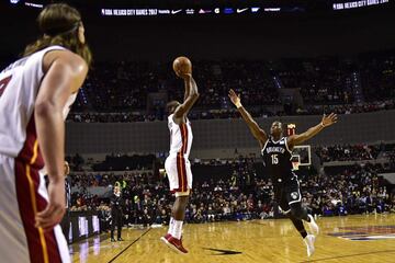 Brooklyn Nets' Isaiah Whitehead (R) jumps to stop a shoot by Miami Heat's Dion Waiters, during their NBA Global Games match at the Mexico City Arena, on December 9, 2017, in Mexico City. / AFP PHOTO / PEDRO PARDO