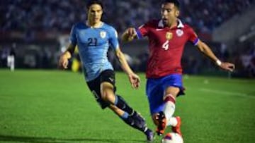 El jugador de Uruguay Edinson Cavani (i) disputa el balón con el jugador de Chile Mauricio Isla (d).