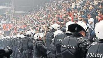 <b>UNA AFICIÓN CALIENTE. </b>Una hilera de policías vigila a la afición del Estrella Roja en el partido frente al PAOK de Salónica el pasado 5 de diciembre en la Sala Pionir.
