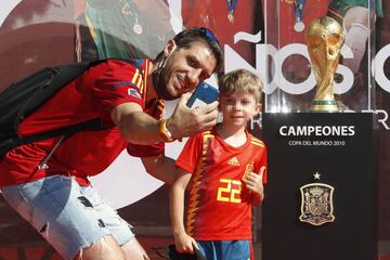 Seguidores de la selección española de fútbol se fotografían junto al trofeo. 