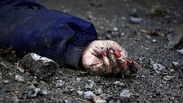 A body of a woman, who according to residents was killed by Russian army soldiers, lies on the street, amid Russia invasion on Ukraine in Bucha