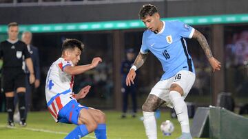Paraguay's midfielder #14 Andres Cubas and Uruguay's defender #16 Mathias Olivera fight for the ball during the 2026 FIFA World Cup South American qualifiers football match between Paraguay and Uruguay at the Defensores del Chaco stadium in Asuncion on June 5, 2025. (Photo by DANIEL DUARTE / AFP)