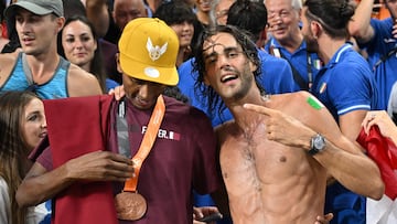 First-placed Italy's Gianmarco Tamberi celebrates with third-placed Qatar's Mutaz Essa Barshim after winning the men's high jump final during the World Athletics Championships at the National Athletics Centre in Budapest on August 22, 2023. (Photo by ANDREJ ISAKOVIC / AFP)