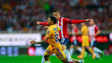 AME2540. GUADALAJARA (MÉXICO), 28/05/2023.- Ronaldo Cisneros (d) del Guadalajara disputa hoy el balón con Javier Aquino de Tigres, durante la vuelta de la final del torneo Clausura 2023 de la Liga MX en el Estadio Akron en Guadalajara, Jalisco (México). EFE/ Francisco Guasco