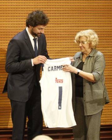 Manuela Carmena recibe una camiseta de manos de Sergio Llull.