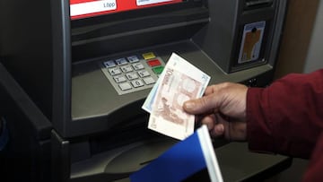 Un hombre retira euros de un cajero automático.