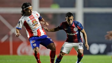 Estudiantes de Merida's midfielder Jesus Gomez (L) and San Lorenzo's forward Cristian Barrios fight for the ball during the Copa Sudamericana group stage second leg football match between Argentina's San Lorenzo and Venezuela's Estudiantes de Merida, at the Pedro Bidegain stadium in Buenos Aires, on June 27, 2023. (Photo by Emiliano Lasalvia / AFP)