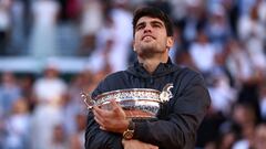 Spain's Carlos Alcaraz celebrates with the trophy after winning against Germany's Alexander Zverev at the end of their men's singles final match on Court Philippe-Chatrier on day fifteen of the French Open tennis tournament at the Roland Garros Complex in Paris on June 9, 2024. (Photo by EMMANUEL DUNAND / AFP)