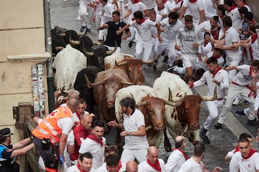 Participantes corren delante de los toros durante el primer encierro de los Sanfermines en Pamplona.