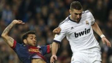 El defensa brasile&ntilde;o Daniel Alves pelea un bal&oacute;n con el delantero franc&eacute;s Karim Benzema durante la ida de semifinales de la Copa del Rey disputada en el estadio Santiago Bernab&eacute;u.