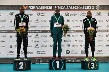 El atleta keniano Kelvin Kiptum (c) celebra su victoria en el podio junto al segundo clasificado Yomif Kejelcha (i) y el tercer clasificado Daniel Mateiko (d) tras la cuadragésima segunda edición del Maratón Valencia.