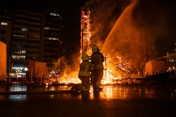 Dos bomberos apagan la Crem de la Falla del Ayuntamiento, a 19 de marzo de 2025, en Valencia.