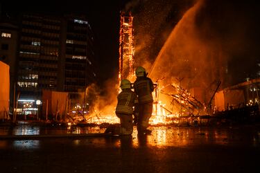 Dos bomberos apagan la Cremà de la Falla del Ayuntamiento, a 19 de marzo de 2025, en Valencia.