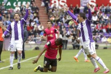 El delantero burkinés del Almería Jonathan Zongo cae ante los jugadores del Real Valladolid Óscar González y Carlos Peña durante el partido de la trigésima primera jornada de Liga de Primera división disputado esta mañana en el estadio José Zorrilla de Valladolid. 