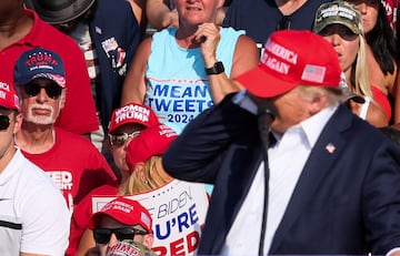 El expresidente, Donal Trump, es evacuado por el servicio secreto del estrado, con algo de sangre  en el rostro, tras escucharse disparos. El candidato republicano ha salido por su propio pie con el puño en alto.