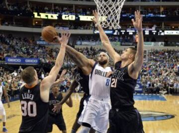 Deron Williams de los Dallas Mavericks intenta encestar ante Alex Len y Jon Leuer.