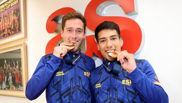 Nico García (izquierda) y Adrián Abadía (derecha) muerden sus medallas mundiales de bronce en su visita a AS.