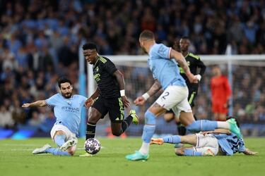Vinicius Junior avanza con el balón controlado entre Gündogan,  Walker y Bernardo Silva.