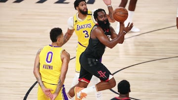 Houston Rockets guard James Harden (13) passes the ball between Los Angeles Lakers forward Kyle Kuzma (0) and forward Anthony Davis (3) during the second half of an NBA basketball game Thursday, Aug. 6, 2020, in Lake Buena Vista, Fla. (Kim Klement/Pool Photo via AP)