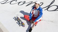 El skater David Gegundez sentado en el asfalto con su tabla de skate. 