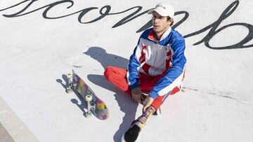 El skater David Gegundez sentado en el asfalto con su tabla de skate.