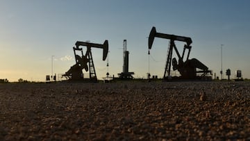 FILE PHOTO: Pump jacks operate in front of a drilling rig in an oil field in Midland, Texas U.S. August 22, 2018. REUTERS/Nick Oxford/File Photo