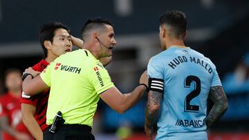 Vigo (Pontevedra),17/04/2023.- El colegiado Ortiz Arias conversa con el defensa del Celta, Hugo Mallo (d) y el centrocampista coreano del Mallorca, Kang-In Lee, durante el encuentro correspondiente a la jornada 29 de primera división que disputan hoy lunes en el estadio de Balaidos, en Vigo. EFE / Salvador Sas.
