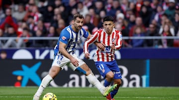 Alaves' Spanish defender #17 Jonny Castro fights for the ball with Atletico Madrid's Argentine midfielder #11 Thiago Almada during the Spanish league football match between Club Atletico de Madrid and Deportivo Alaves at Metropolitano Stadium in Madrid on January 18, 2026. (Photo by Oscar DEL POZO / AFP)