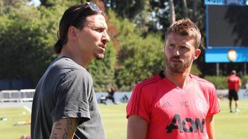 Zlatan Ibrahimovic charla con Michael Carrick durante su visita al entrenamiento del Manchester United.