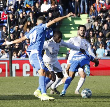 El jugador del Real Madrid, Mendy, trata de llevarse el balón ante los jugadores del Getafe. 