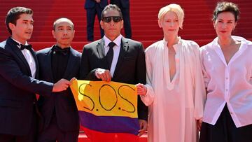 (From L) Colombian actor Juan Pablo Urrego, Thai director Apichatpong Weerasethakul, Colombian actor Elkin Diaz, British actress Tilda Swinton and French actress Jeanne Balibar pose with a Colombian flag reading "SOS" in support of anti-governments protests in Colombia as they arrive for the screening of the film "Memoria" at the 74th edition of the Cannes Film Festival in Cannes, southern France, on July 15, 2021. (Photo by John MACDOUGALL / AFP)