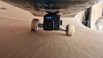 Una cámara GoPro Hero11 Black enganchada bajo una tabla de skate.