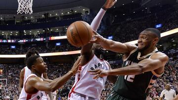 Milwaukee Bucks forward Jabari Parker (12) moves the ball past Toronto Raptors guard Kyle Lowry, left, and forward Patrick Patterson (54) during the second half of an NBA basketball game in Toronto on Friday, Jan. 27, 2017. (Nathan Denette/The Canadian Press via AP)