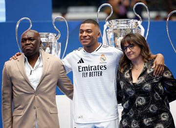 Wilfried Mbappé y Fayza Lamari, padre y madre de Kylian, escoltando al jugador en su presentación de blanco.