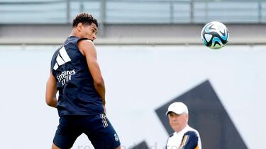 Jude Bellingham remata de cabeza un balón ante la atenta mirada de Ancelotti en el entrenamiento del miércoles en la Ciudad Real Madrid de Valdebebas.