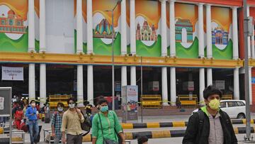 Passengers arriving by various trains, walk outside the railway station after the government eased a nationwide lockdown imposed as a preventive measure against the COVID-19 coronavirus, in New Delhi on May 13, 2020. - India&#039;s enormous railway networ