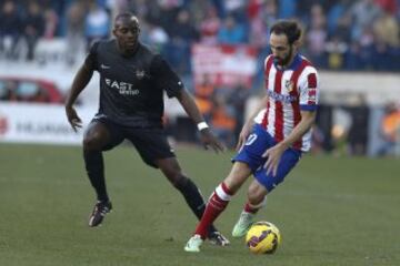 El defensa del Atlético de Madrid Juanfran Torres con el balón ante el delantero brasileño del Levante Rafael Martins, durante el partido de la decimoséptima jornada de Liga de Primera División