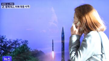 A woman walks past a TV screen broadcasting a news report on North Korea firing a ballistic missile off its east coast, in Seoul, South Korea, November 2, 2022.   REUTERS/Kim Hong-Ji